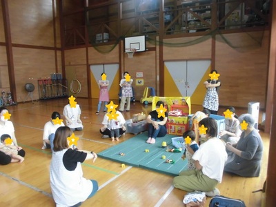 小さな子どもを抱っこしながら保健師さんの話を聞いている写真