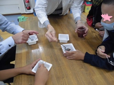 白い四角い器にスプーンで液を入れている様子の写真