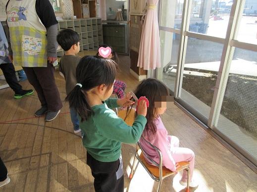 ゆり組の美容室は本格的。ハサミを手にお客さんの髪をカットしています。