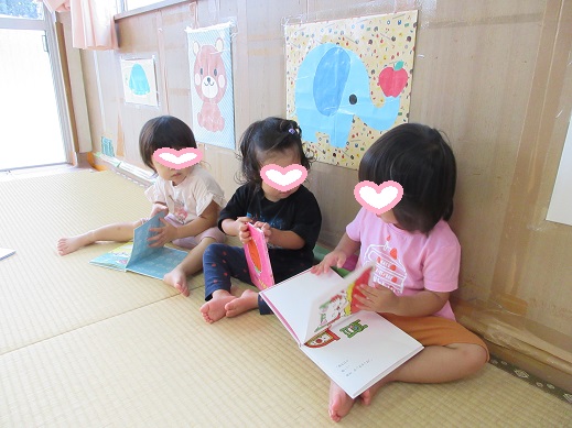 友だちと一緒に絵本を見る1歳児