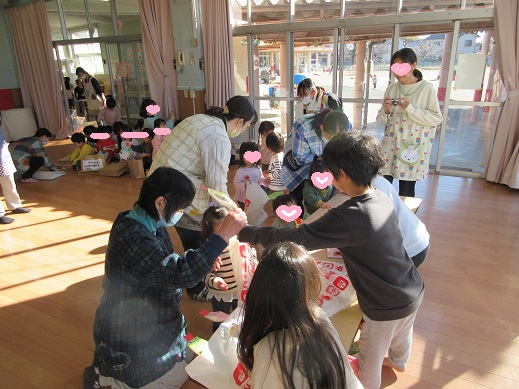 小さい子に優しくおもちゃセットを渡す様子
