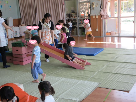 ホールを走ったり滑り台を楽しんだりする1・2歳児