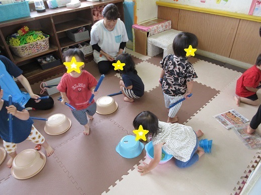 桶と新聞紙の棒で太鼓ごっこを楽しむ様子