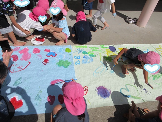 大きな紙に絵を描く5歳児