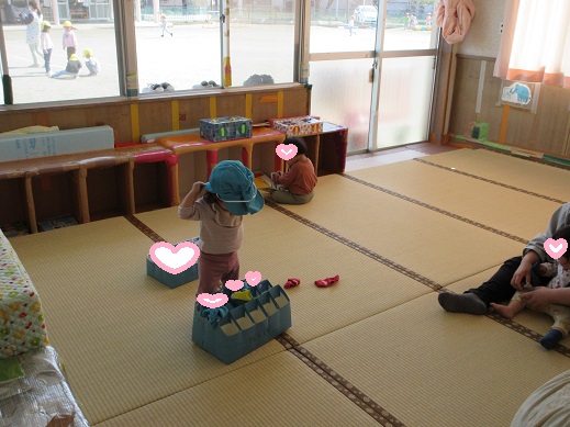 自分で帽子を被ろうと頑張る1歳児ばら組