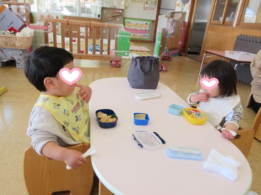 手掴みやスプーンで、お弁当を食べるちゅうりっぷ組の子どもたち