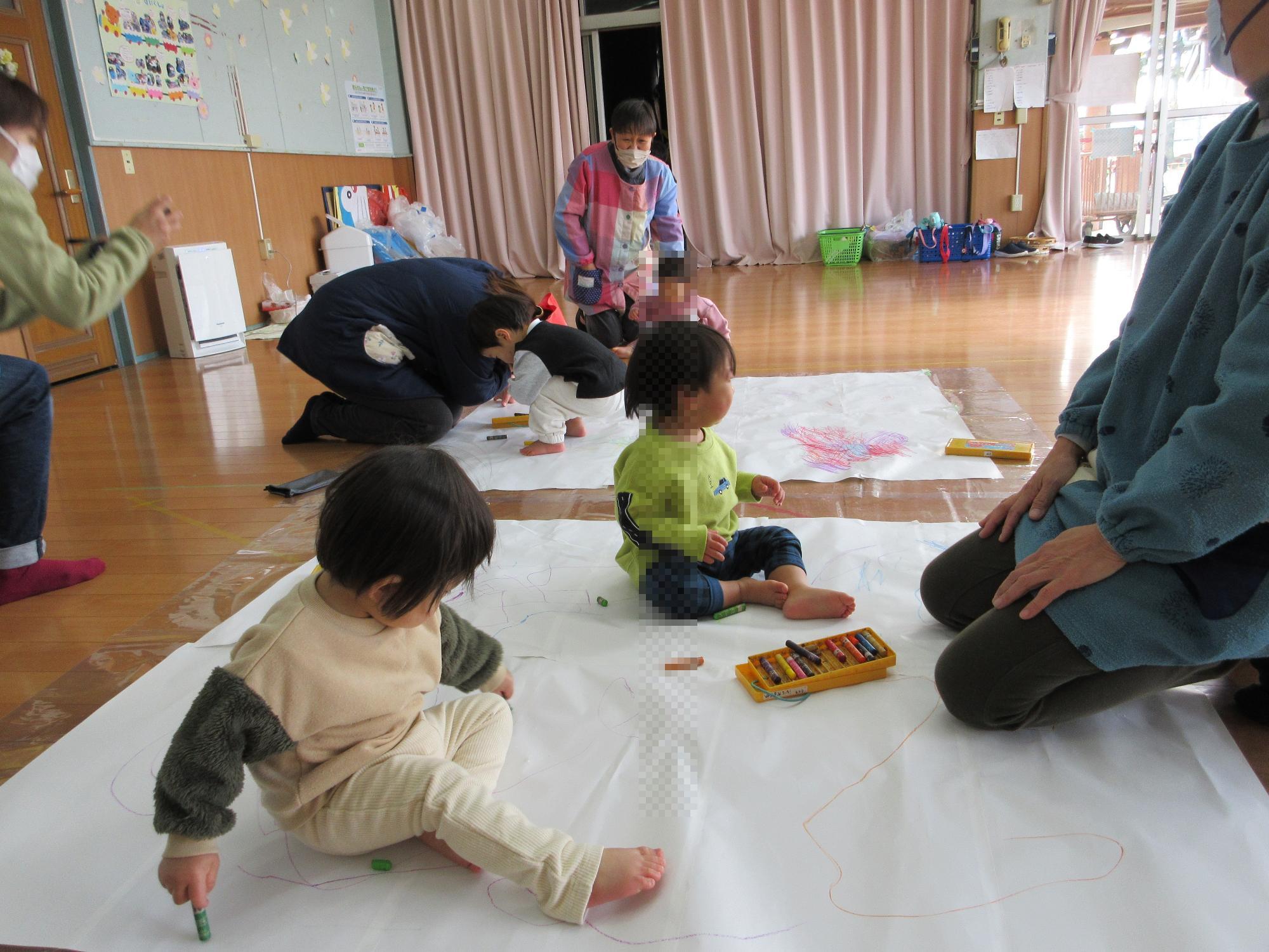 大きな紙にお絵かきする0歳児