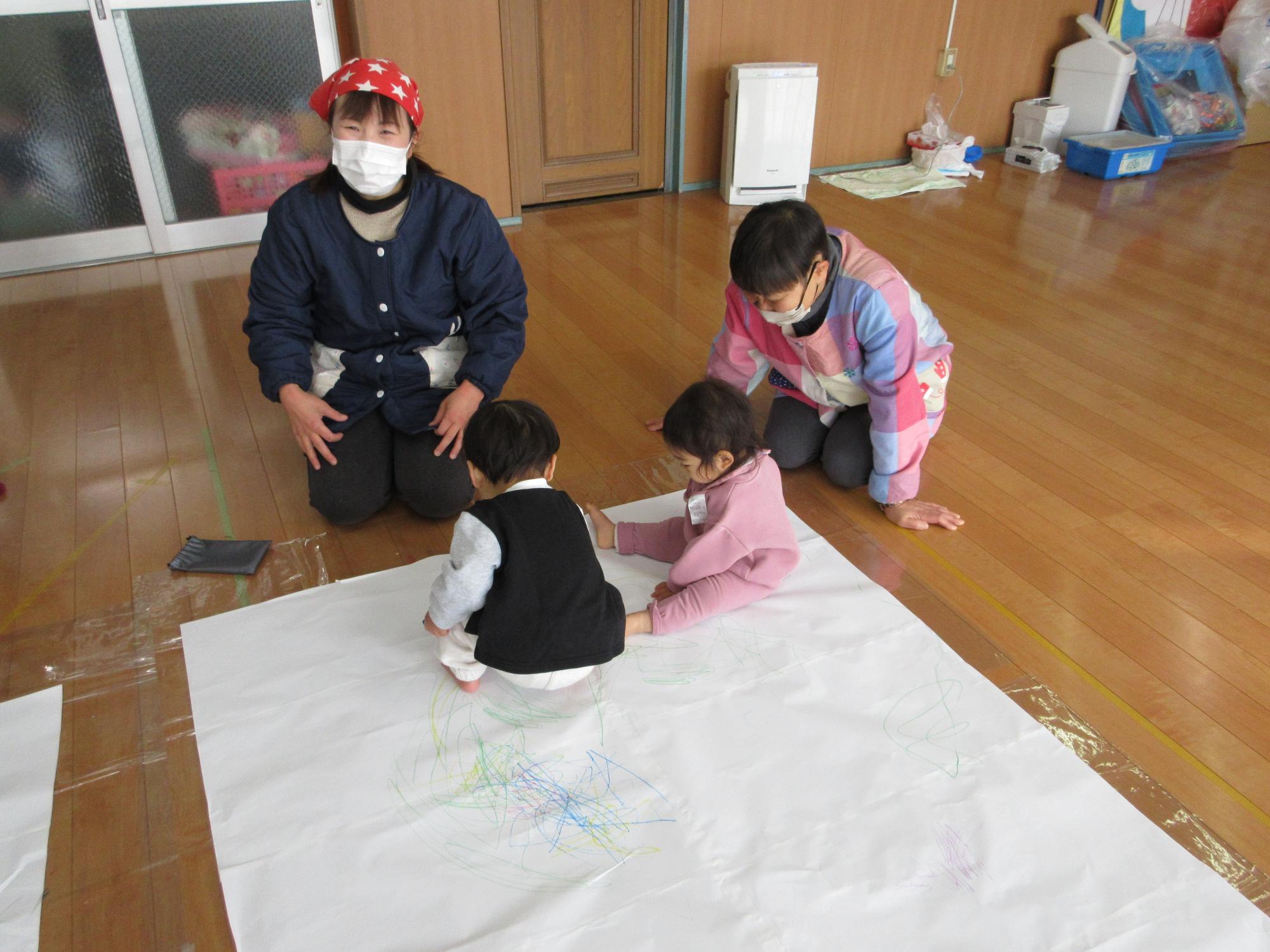大きな紙にお絵かきする0歳児