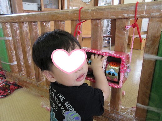 くるりと玩具が回り、振り返り保育士を見て喜ぶ0歳児