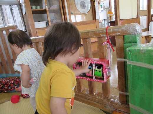 回して楽しむ友だちの様子を見て興味を持つ0歳児