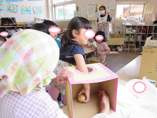 箱に手を入れじゃが芋を掴む様子