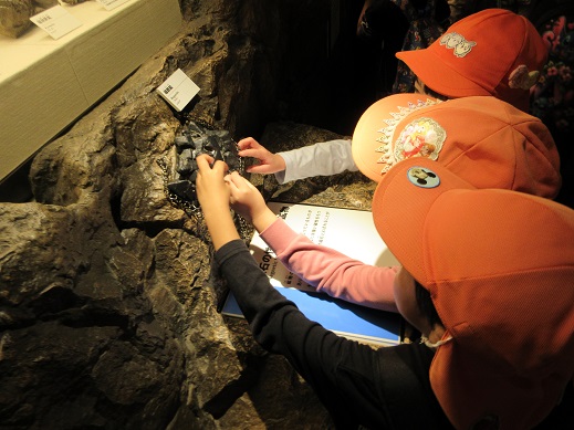 磁石の石に鎖が付くか試している様子