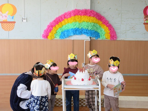 誕生日ケーキを見て喜ぶ誕生日の子どもたち