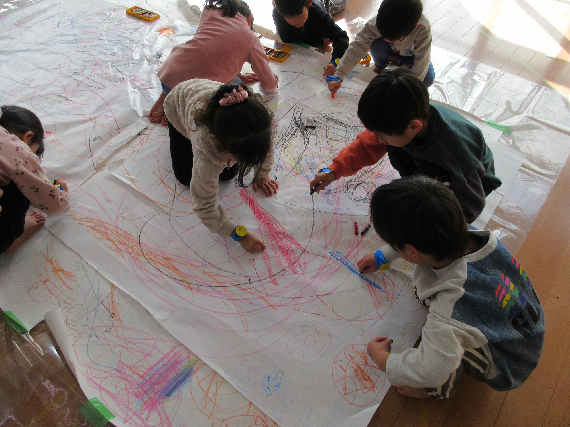 大きな紙に思い切りお絵かきする5歳児