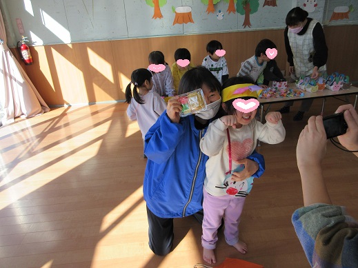 欲しいものを買えて喜びカメラに向かってポーズする所長先生と子ども