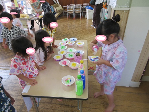 かき氷屋さんになりきり、シロップをかける様子