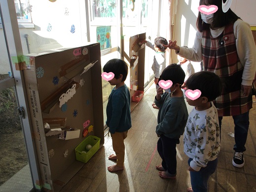 氷の玉を見立てた玉を上から転がし、ジグザクに落ちていく様子を楽しむこどもたち