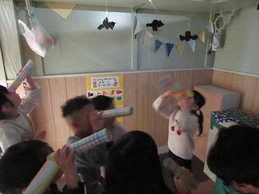 望遠鏡を見立てた筒で、夜の森(暗い部屋)で蝙蝠を探す子どもたち