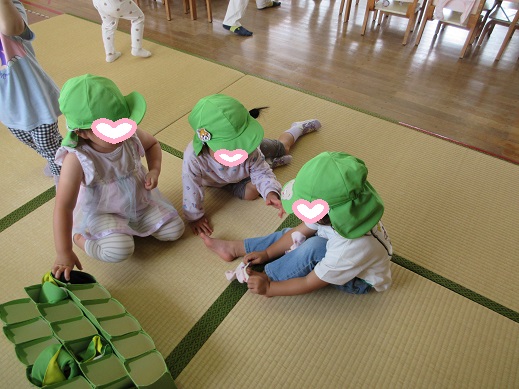 2歳児もも組の子どもたちが自分で靴下を履く様子