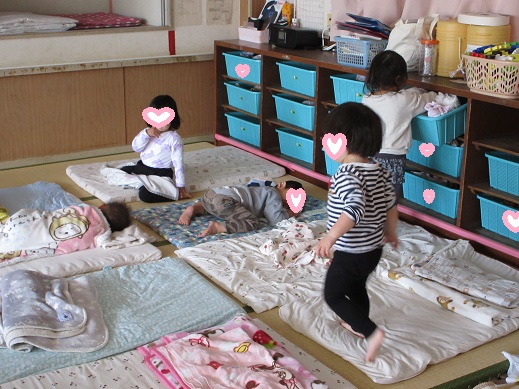 いっぱい遊んで、いっぱい食べておやすみなさいと布団に入る2歳児もも組。自分で着替えを選んでいるこもいます。