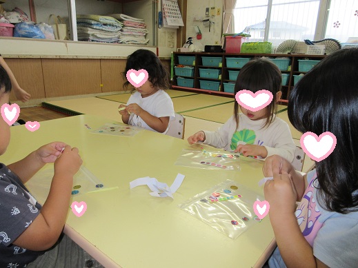 台紙からシールを剥がす2歳児