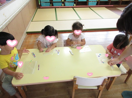 シールを台紙から剥がす2歳児