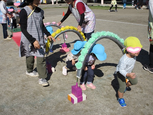 お花のトンネルをくぐる2歳児
