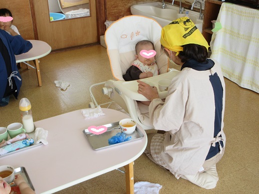 スプーンに乗せた離乳食(初期)を、ゆっくり口を開けて食べる0歳児