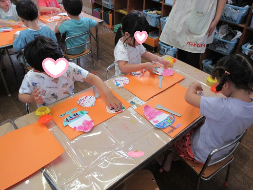かき氷やヨーヨーを糊付けする4歳児