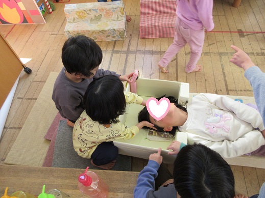 シャワー付きのシャンプー台に寝て髪を洗っています。