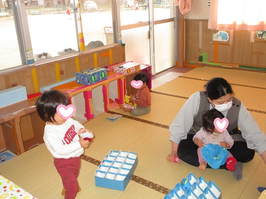 外遊びに行こうと準備する中、絵本を楽しむ1歳児