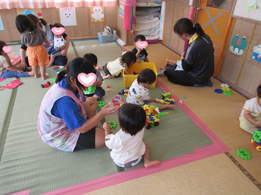 中学生とブロック遊びを楽しむ1歳児
