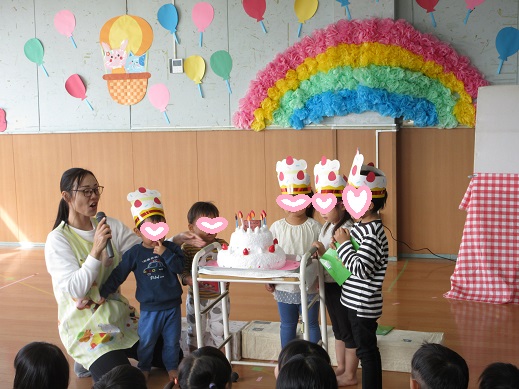 大きな誕生日ケーキの前で記念写真を撮る誕生児