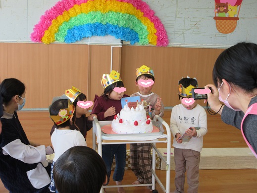 誕生日ケーキの前で記念写真をを撮る様子。