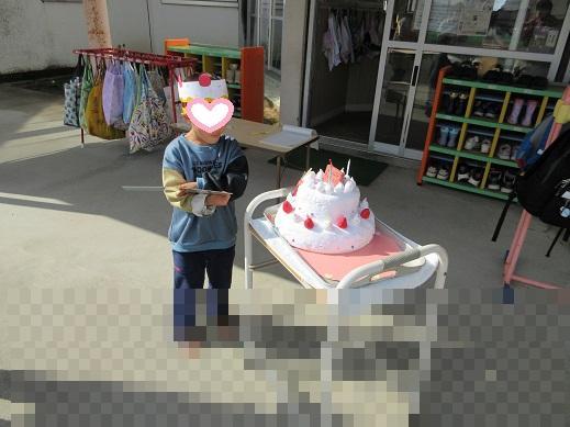 誕生ケーキを前に嬉しそう