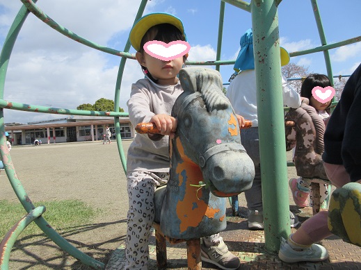 固定遊具の馬に草を食べさせて、元気になった馬に跨り走っている気分の2歳児