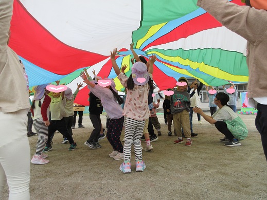 パラバルーンの中で両手を広げる4歳児
