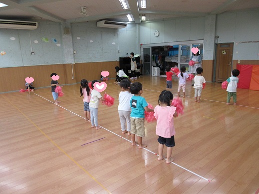 ポンポンを持ち踊る3歳児
