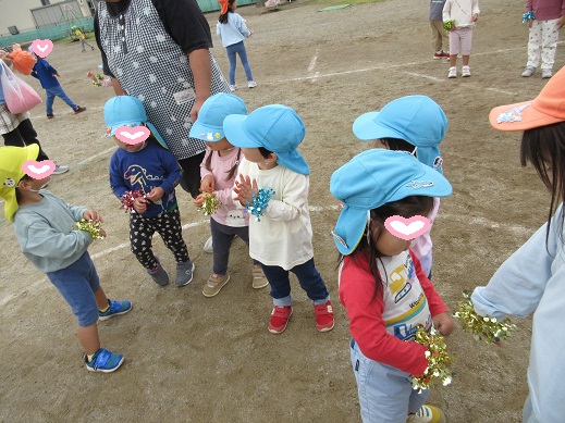 キラキラの飾りを腕につけ喜ぶ2歳児