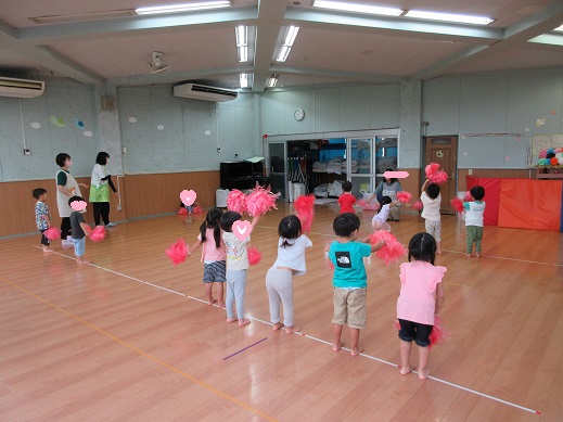 ポンポンを持ち踊る3歳児