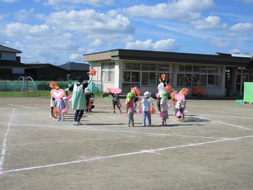 ポンポンを手に踊る3歳児