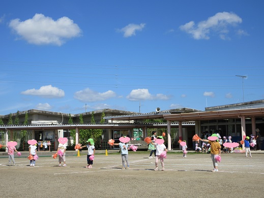 ポンポンを手に踊る3歳児
