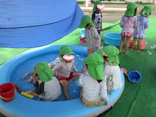 浅い水の中に入ったり色水遊びをたのしんだりする3歳児