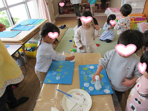 ペットボトルにクッション材を付けてスタンプ遊びを楽しむ3歳児