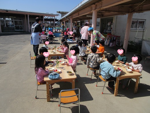 テーブルに花を飾りテラスで会食の様子(ゆり組)