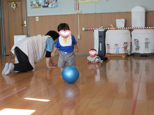 広いホールで這い這いやボール遊びを楽しむ0歳児