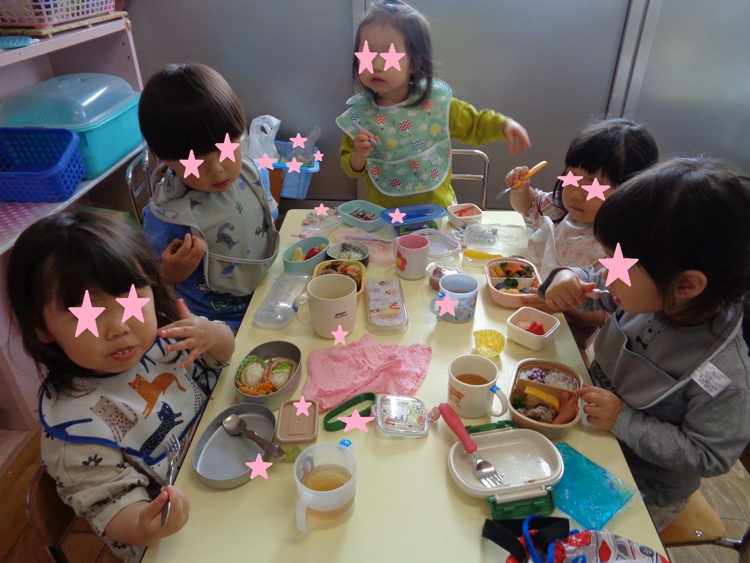 テーブルを囲みお弁当を食べる子どもたち