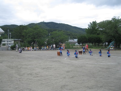 園庭で法被を着た子供たちが太鼓の演奏を行っている様子の写真