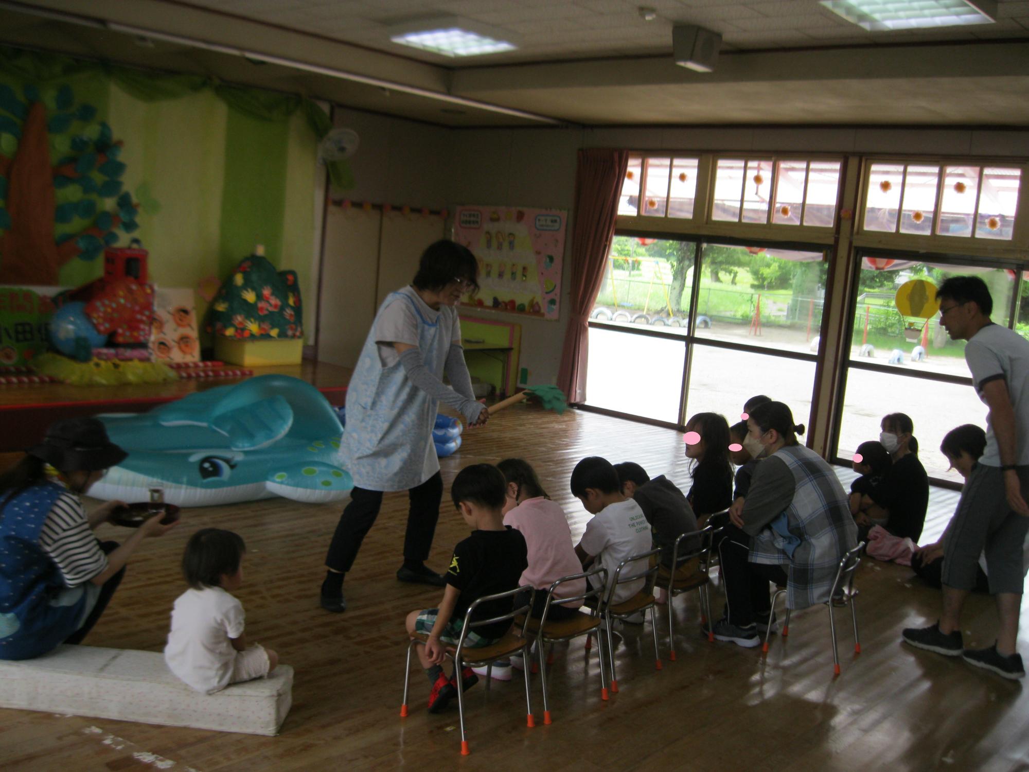 みんなが安全にプール遊びを楽しめるように手作りの榊の葉っぱでお祓いをしている所です。