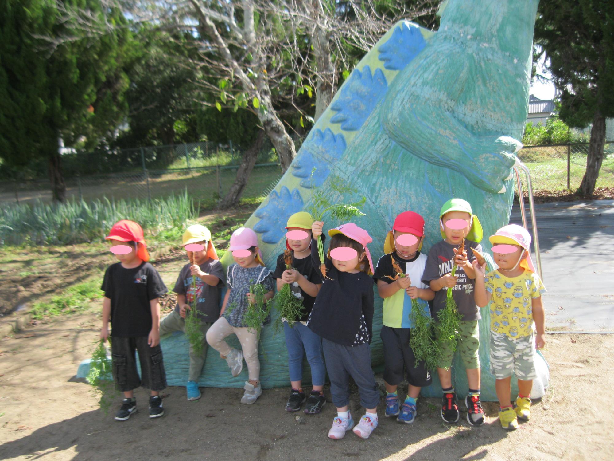 収穫したニンジンを持って写真を撮りました。